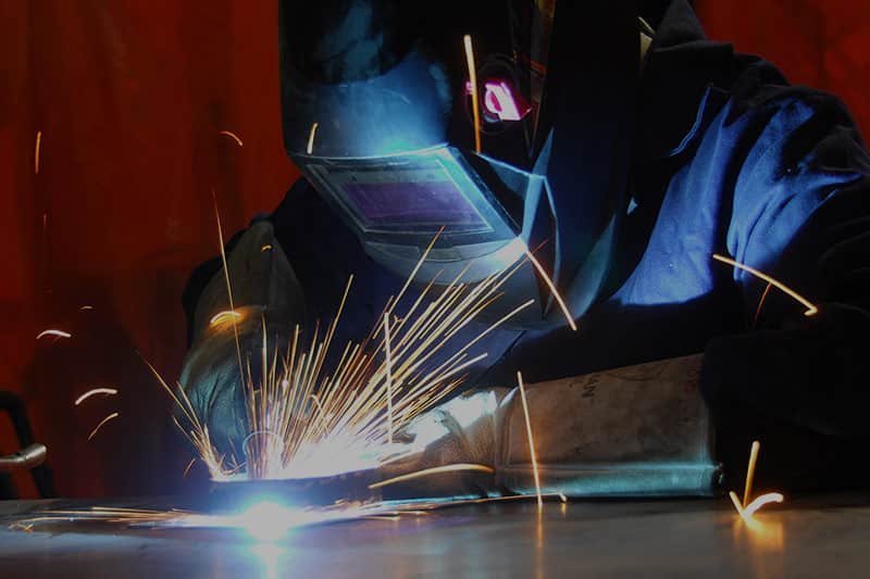 Soldador realizando soldadura industrial